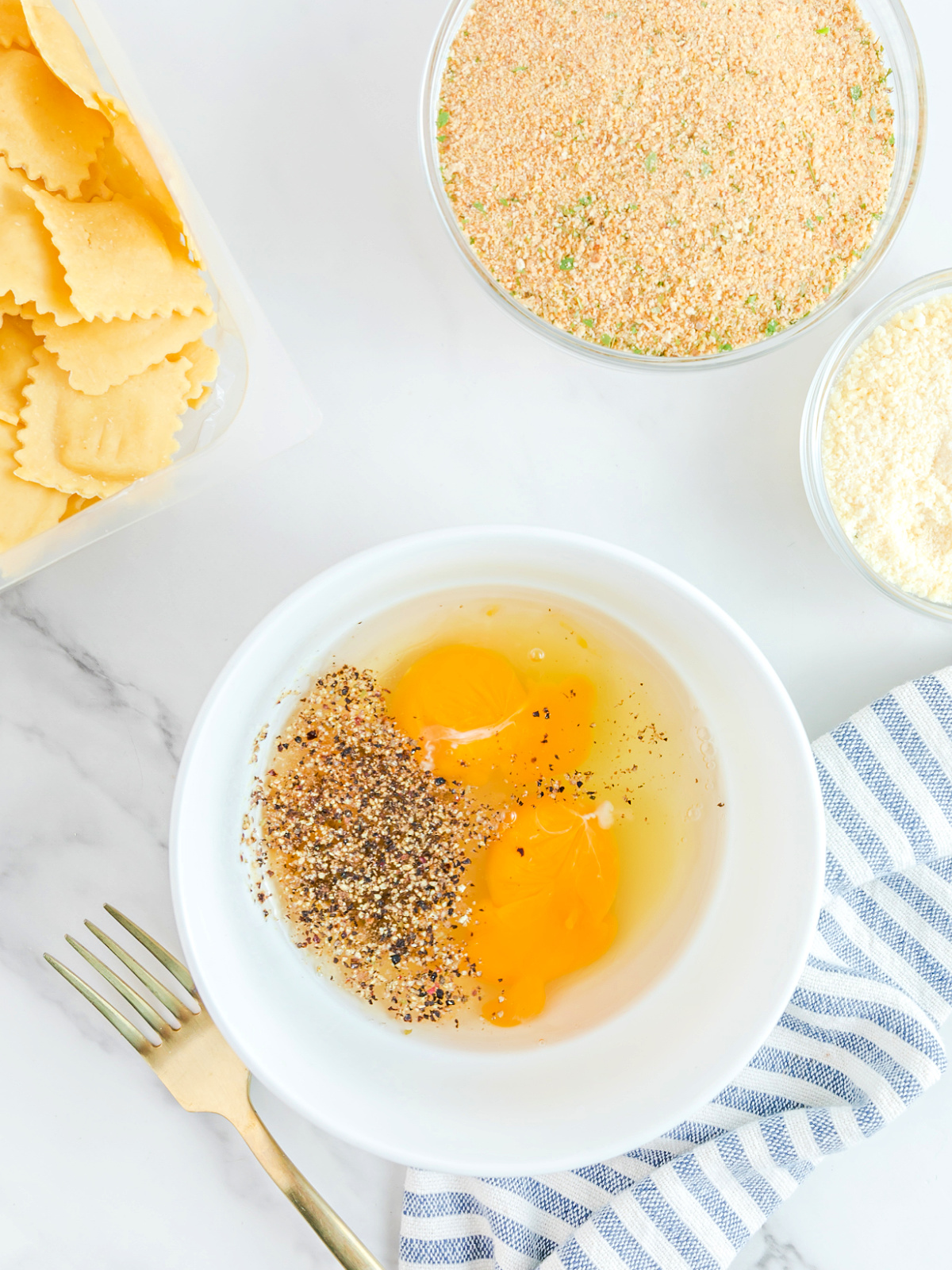 Eggs, water, and seasoning being mixed in a small white bowl.