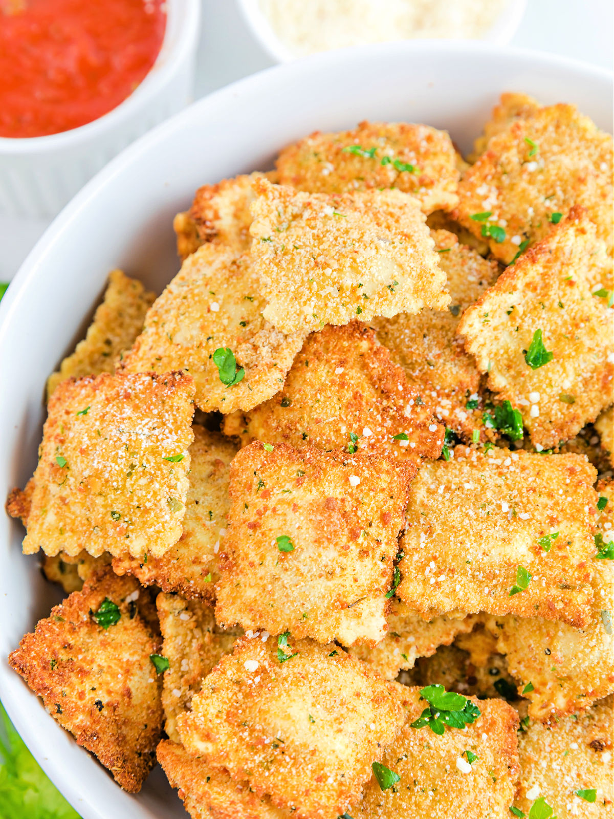 Toasted ravioli in a white bowl.