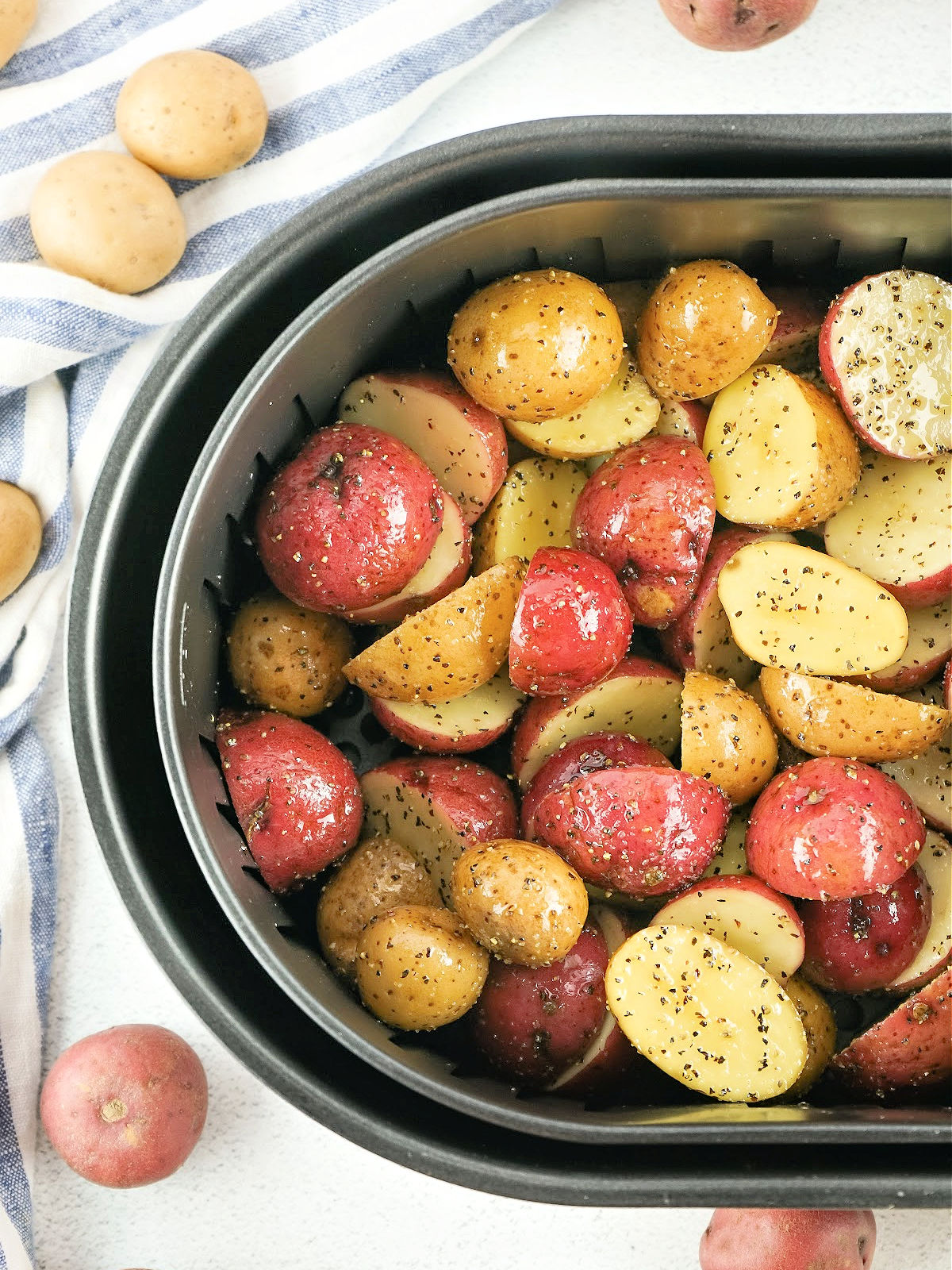 Potatoes in the bowl of an air fryer.