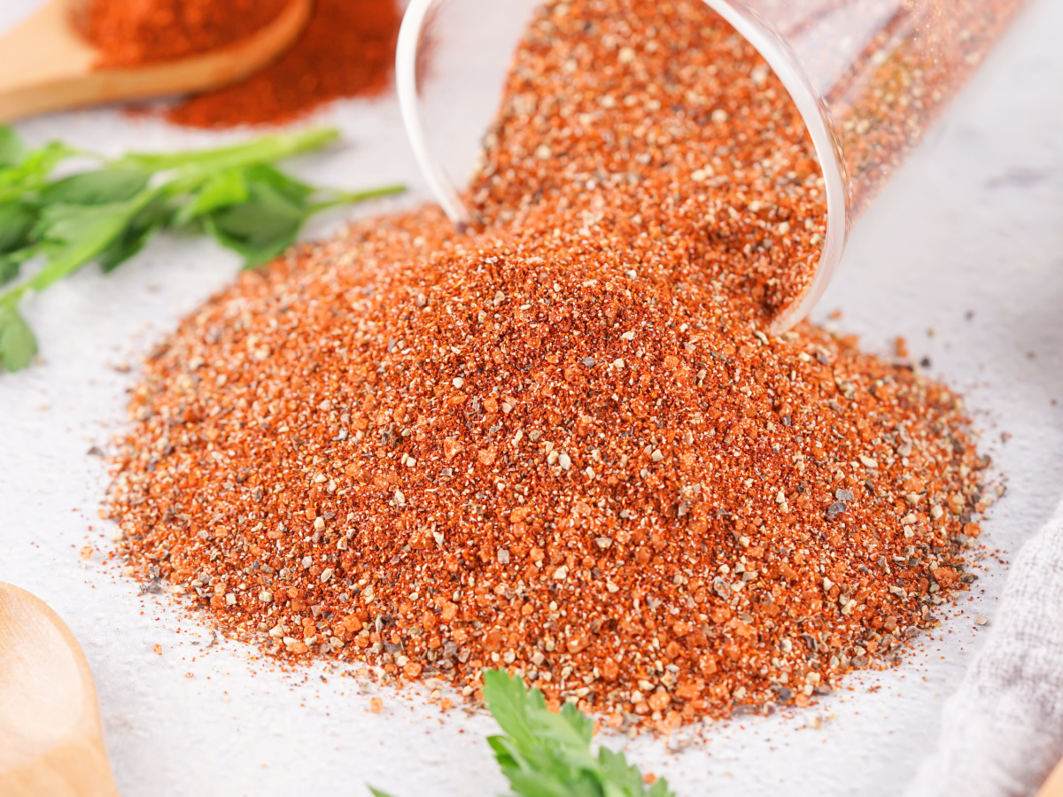 BBQ rub mixture spilling out of a glass jar.