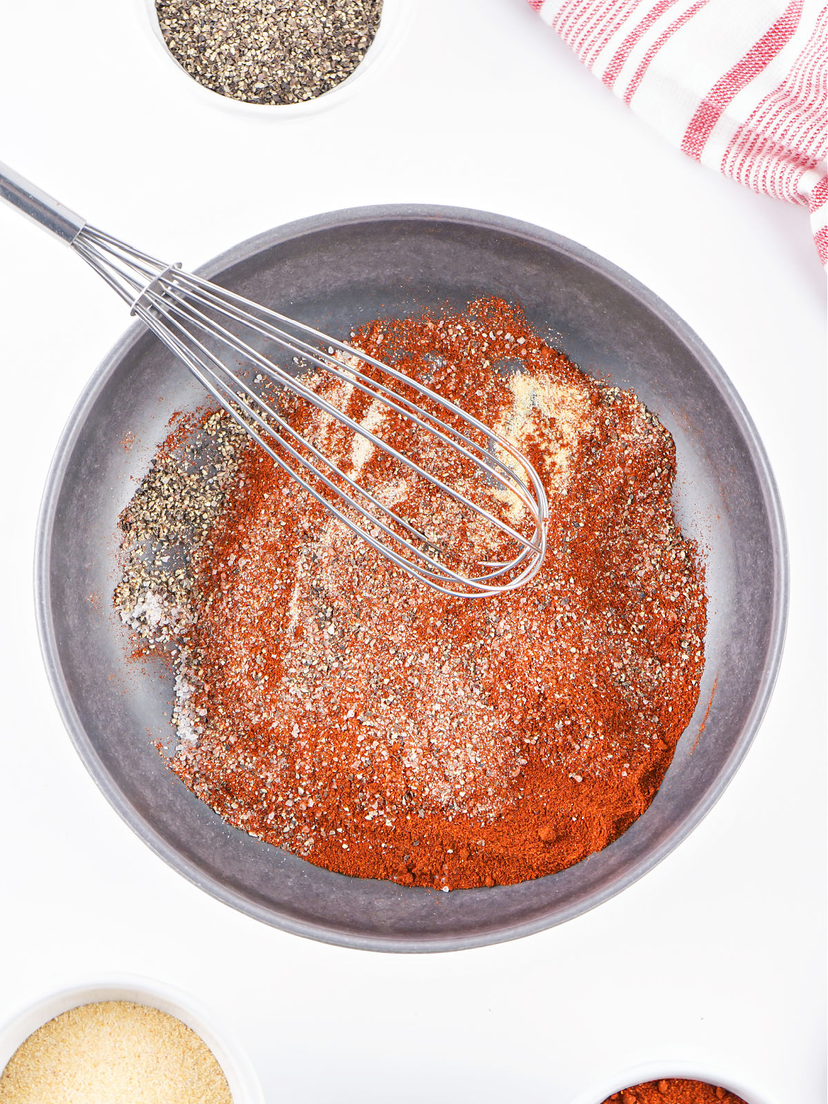 Bowl of spices being whisked together in a gray bowl.