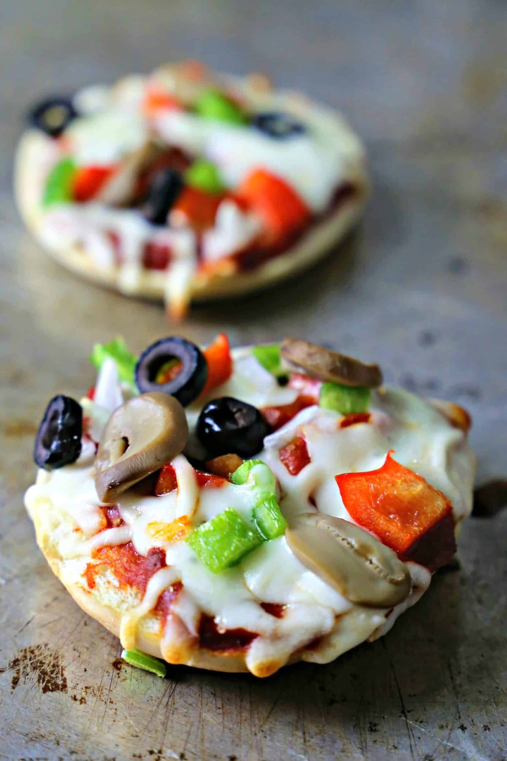 Baked pizza bagel on a sheet pan.