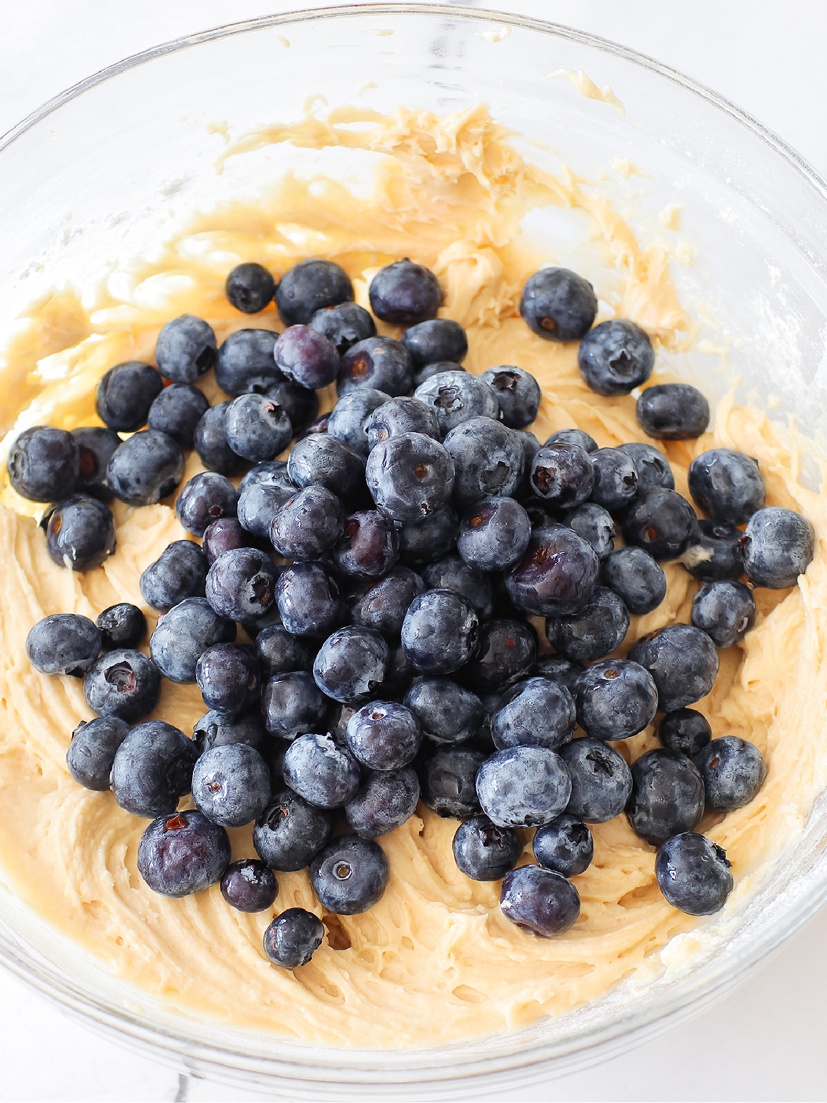 Blueberries on top of muffin batter.