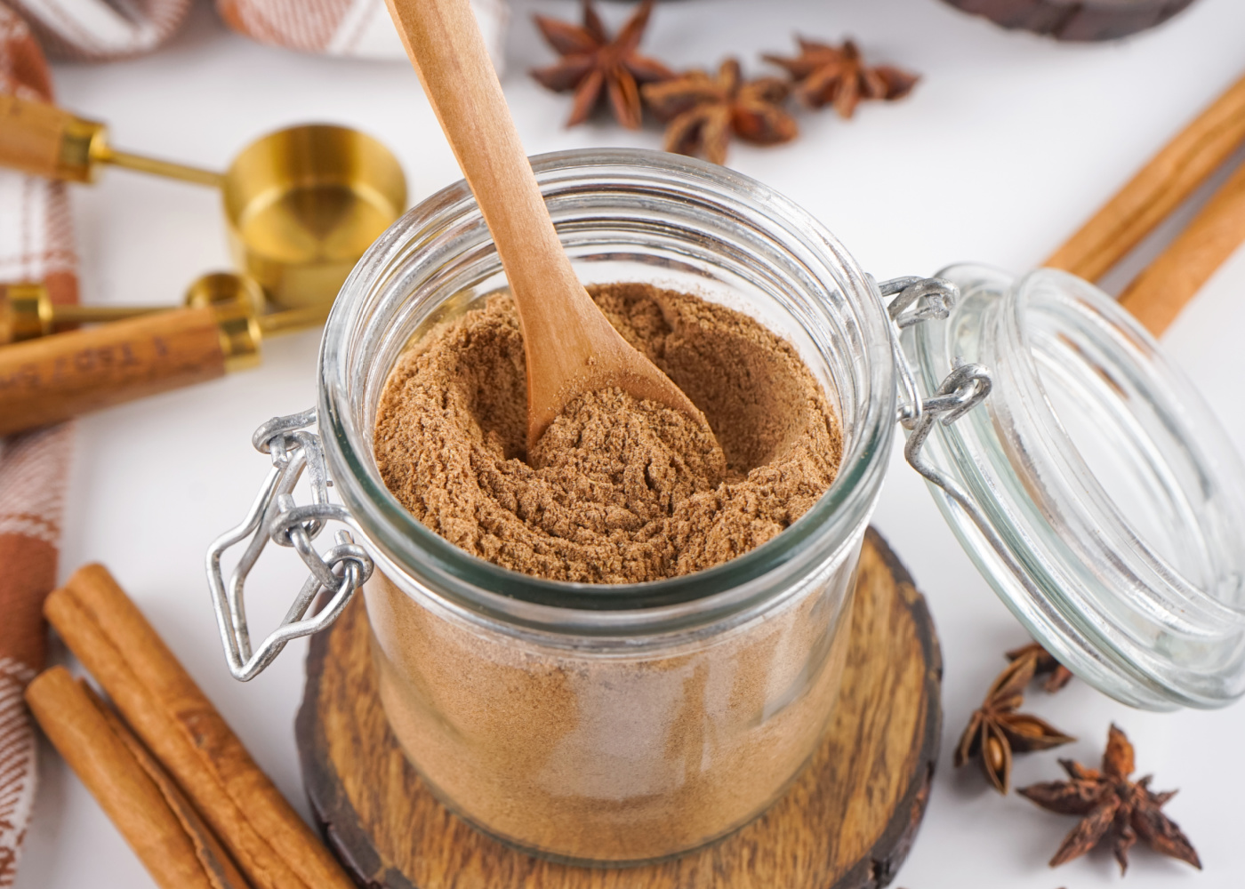 Wooden spoon in a jar of chai spice mix.