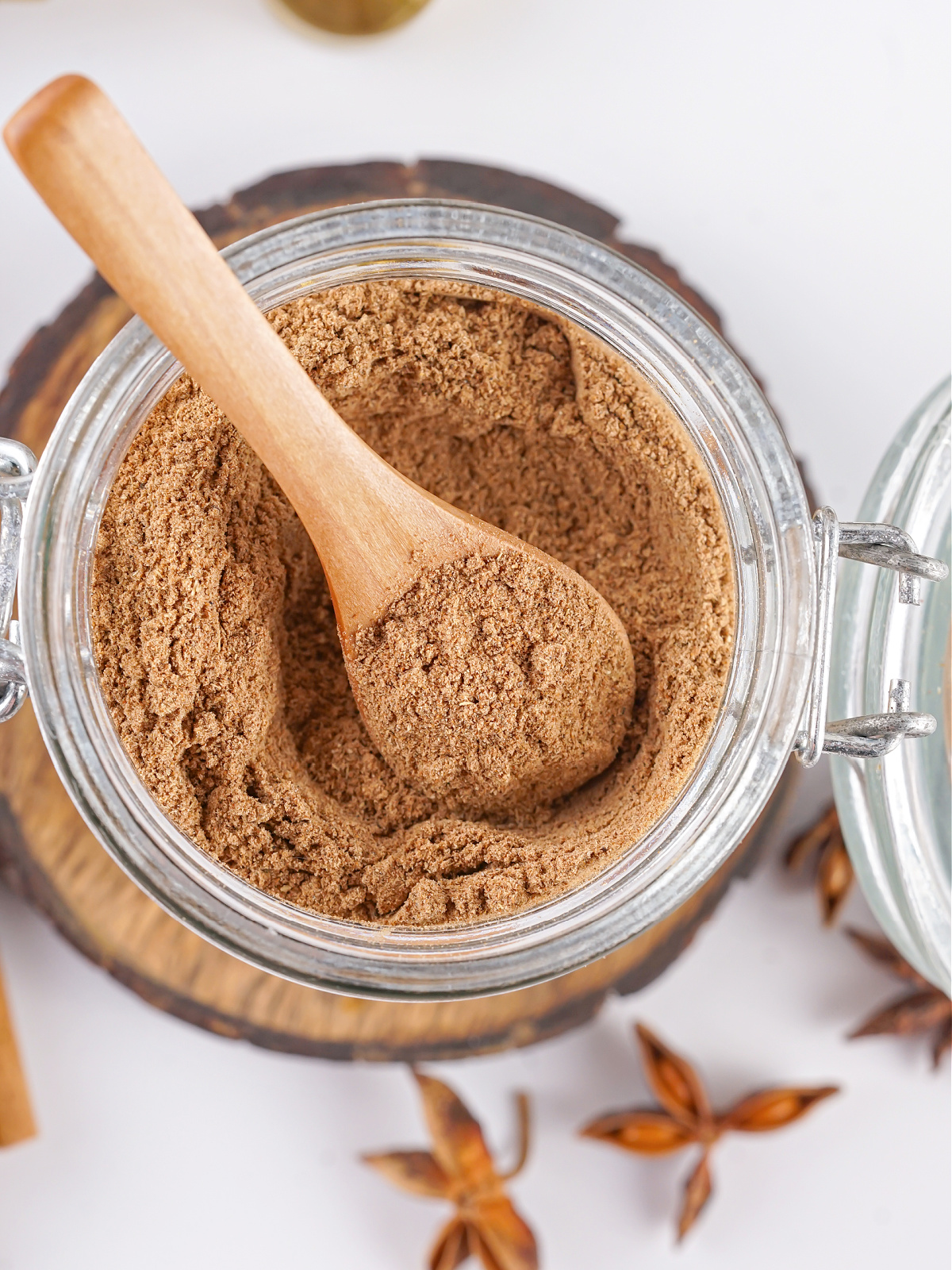 Wooden spoon in a jar of chai spice mix.