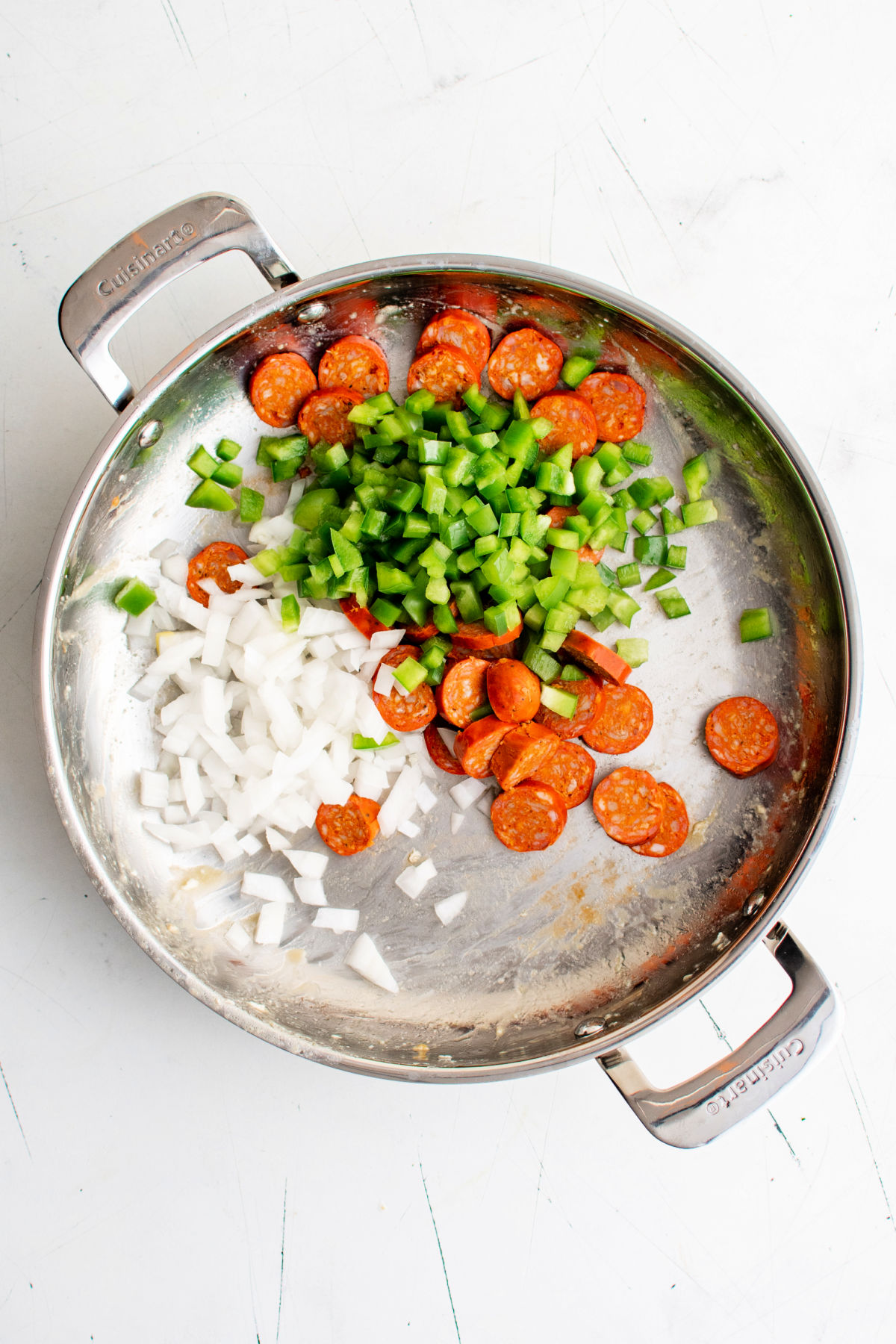 Onions, peppers, and chorizo in a skillet.