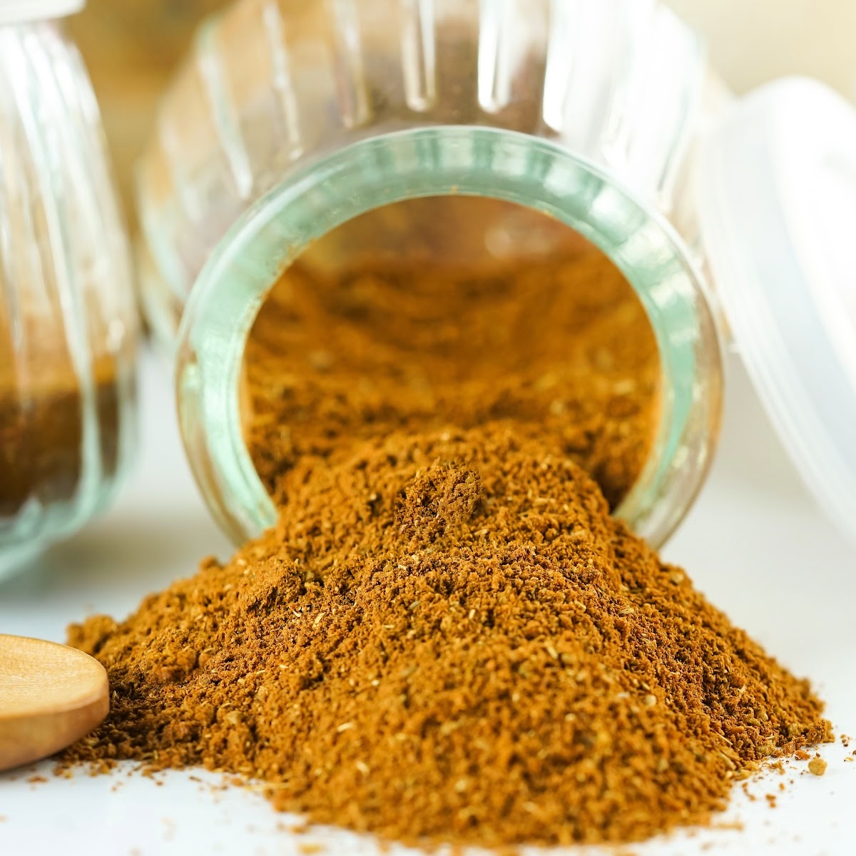 Chinese 5 spice flowing out of a jar onto a counter top.