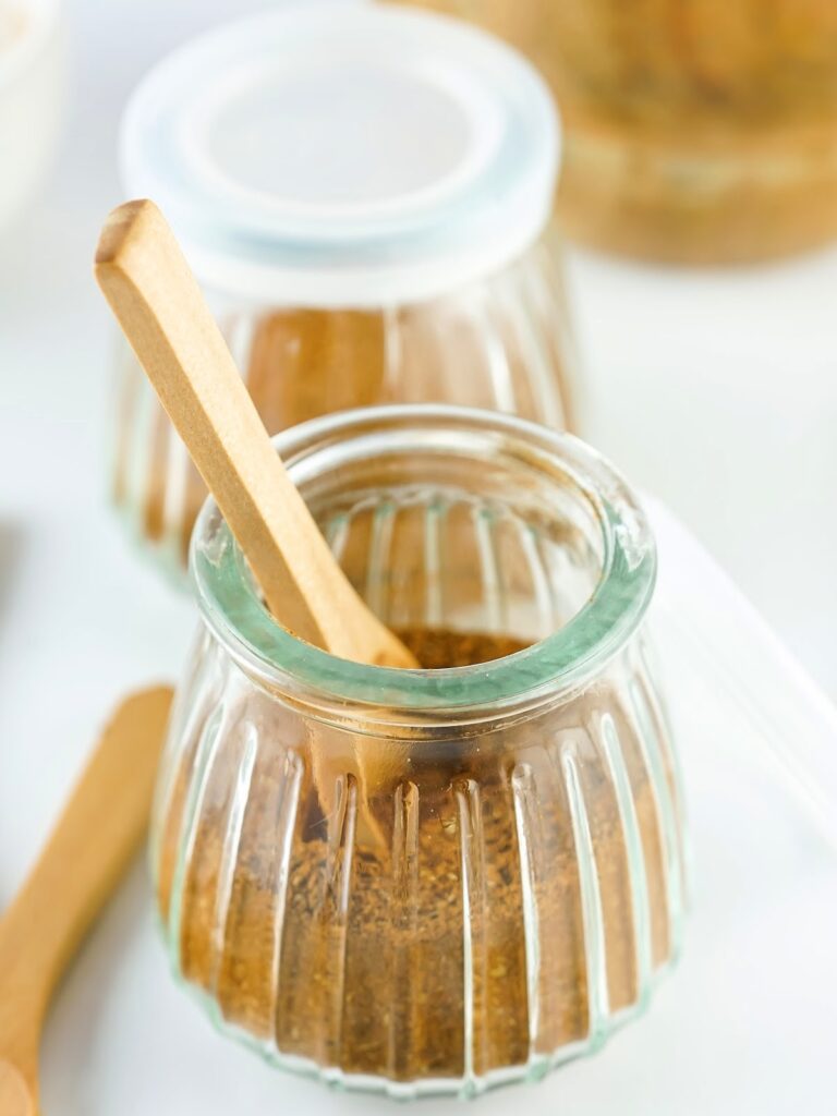 Wooden spoon in a jar of Chinese 5 spice.