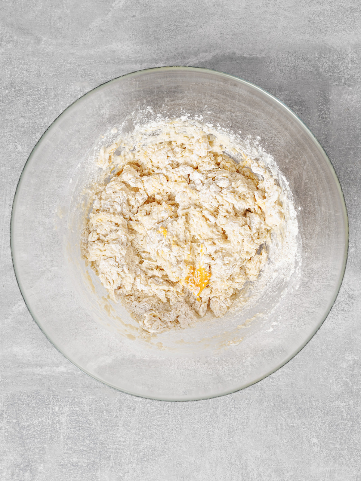 Shaggy dough in a glass mixing bowl.