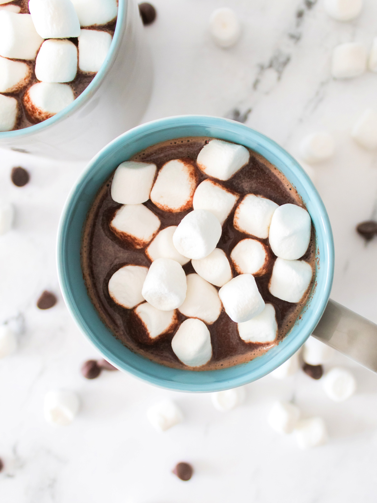 Hot chocolate with miniature marshmallows in a blue mug.