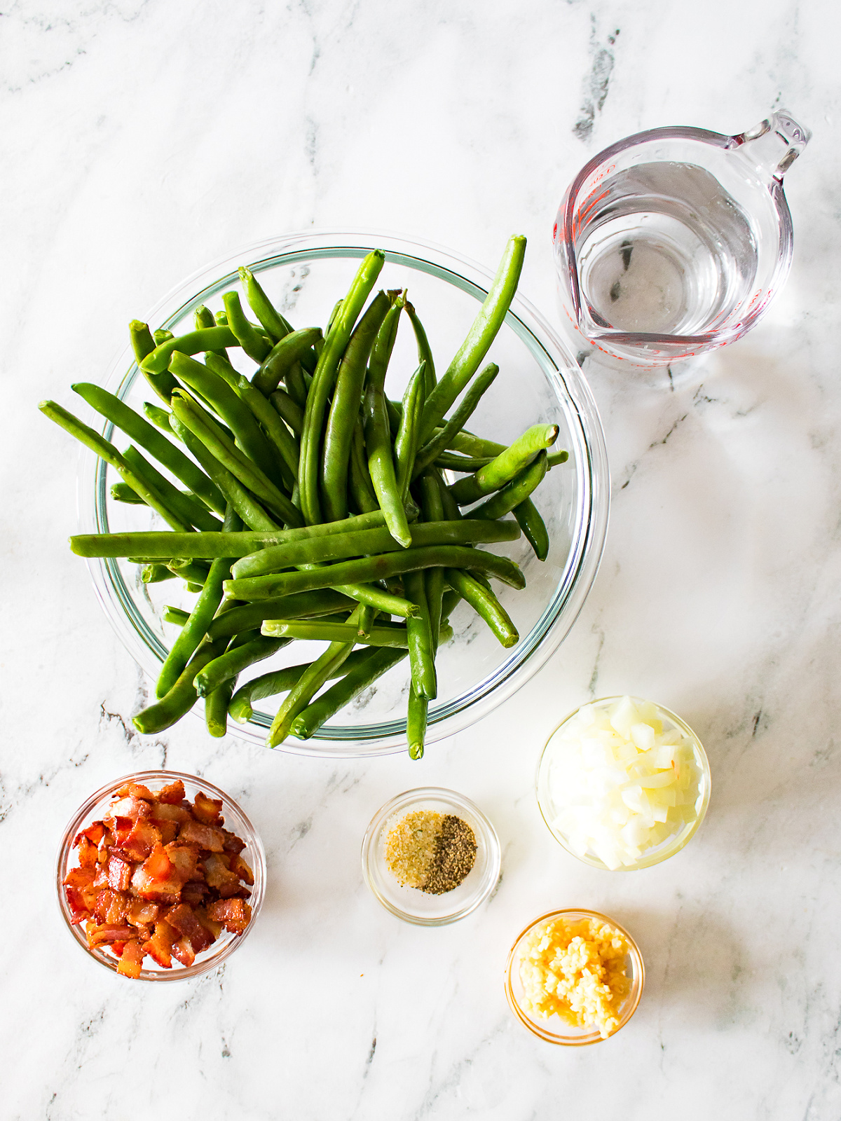 Fresh green beans, bacon pieces, onions, garlic, water, and seasoning.