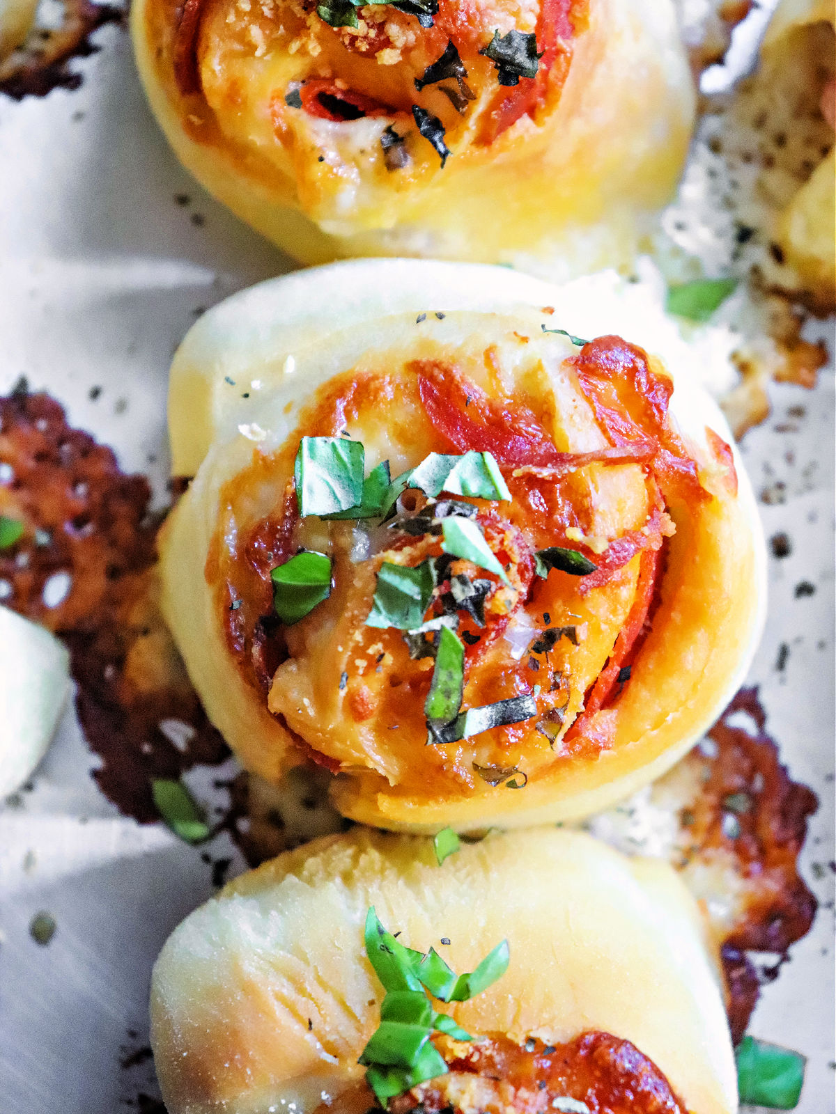 Pepperoni pizza bites topped with basil.