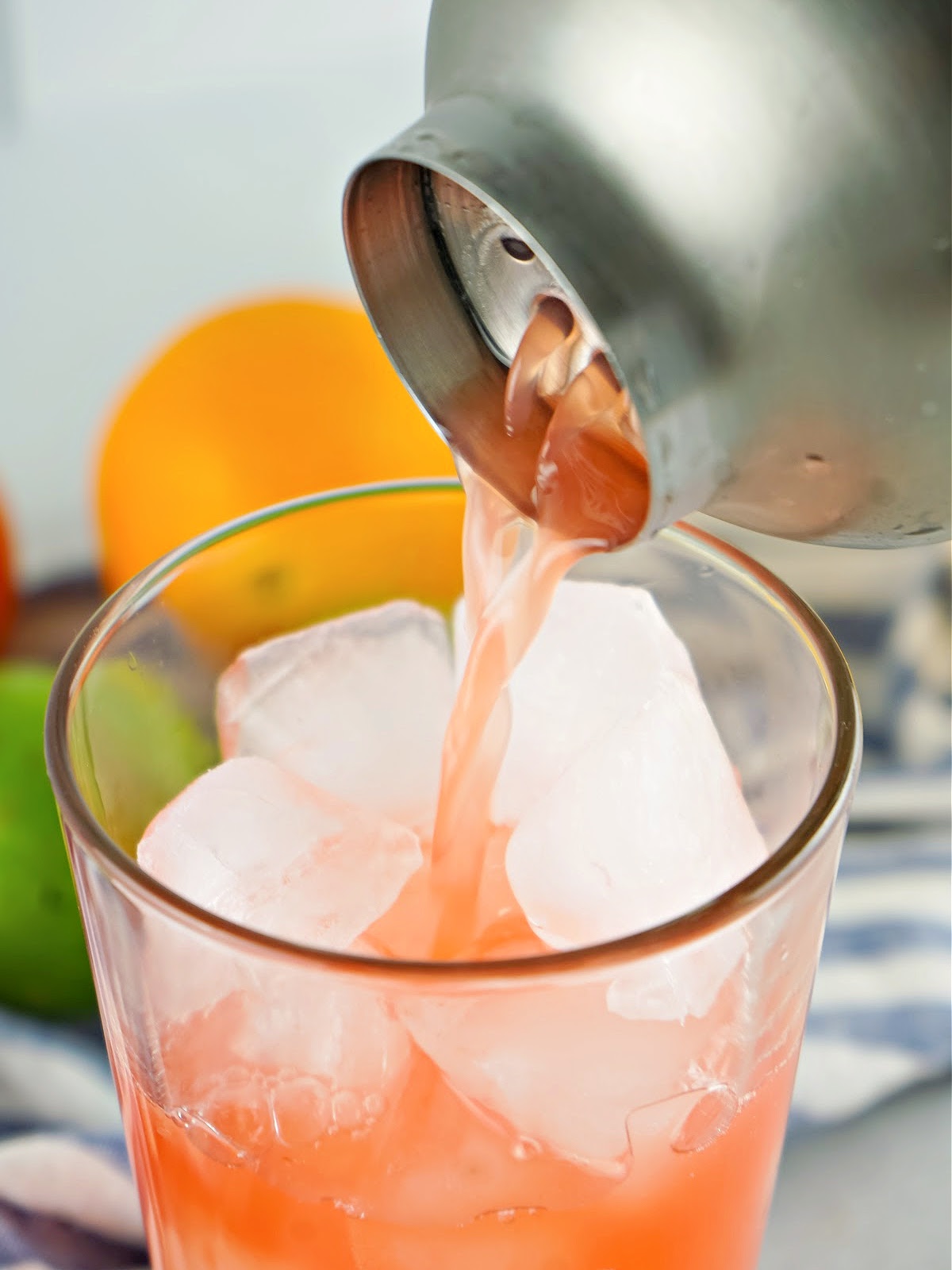 Straining rum punch into a glass.