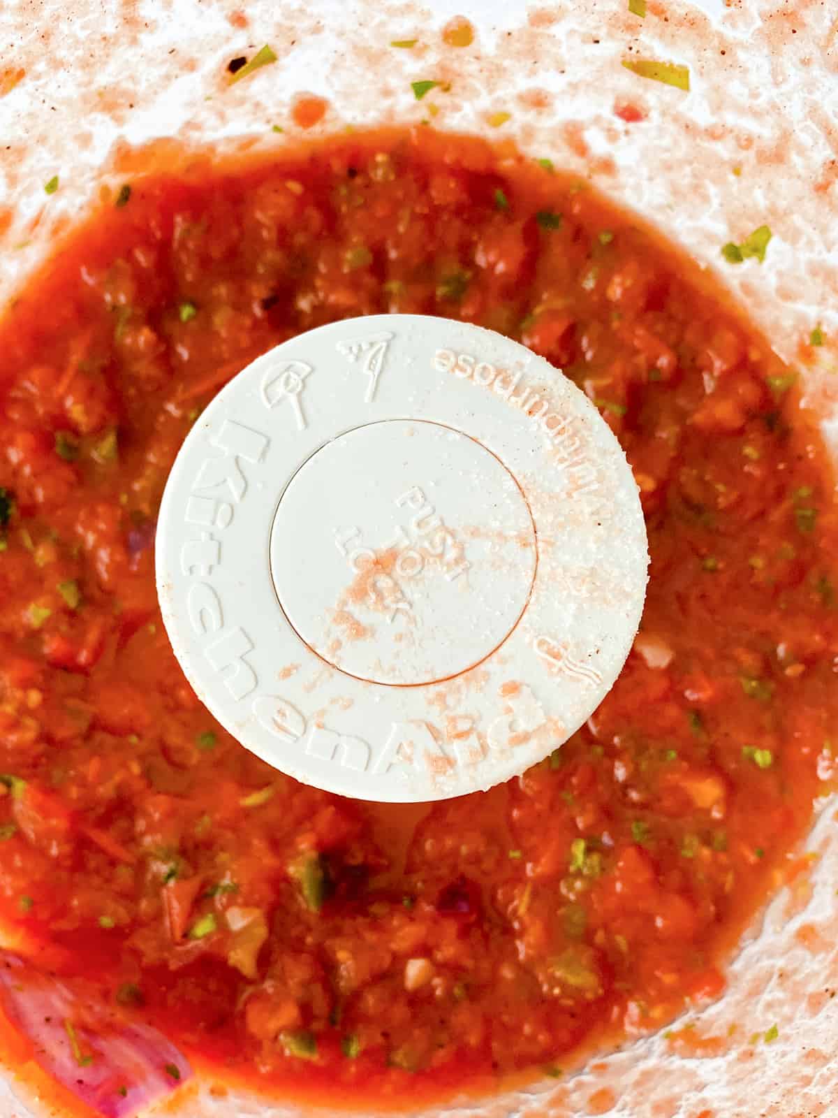 Pureed tomatoes and vegetables in a food processor.