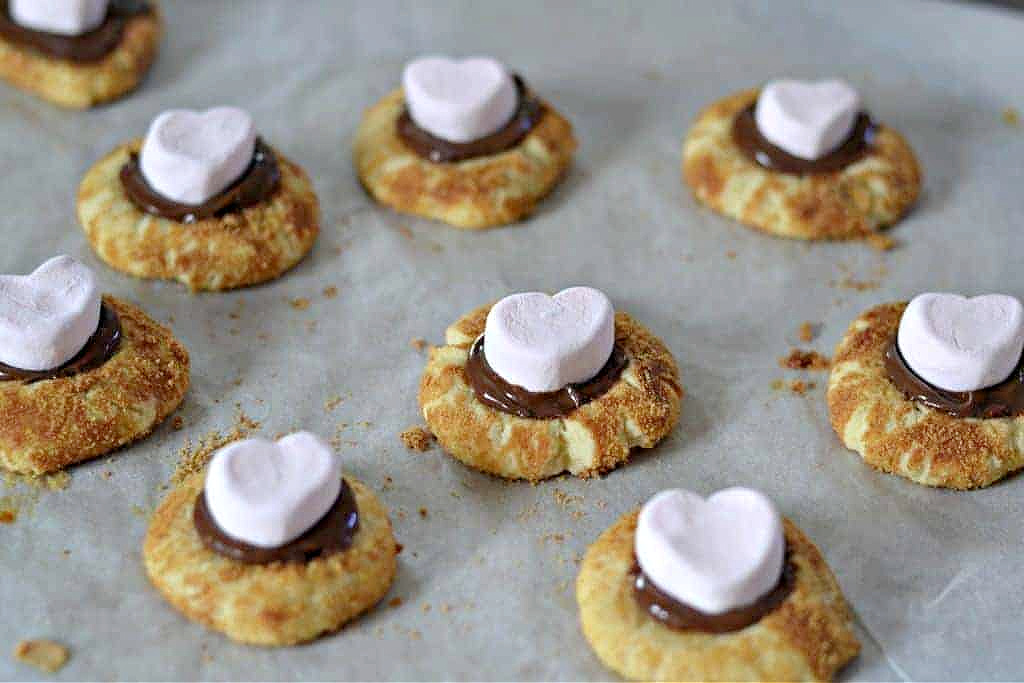 Thumbprint cookies filled with Nutella and topped with heart-shaped marshmallows.