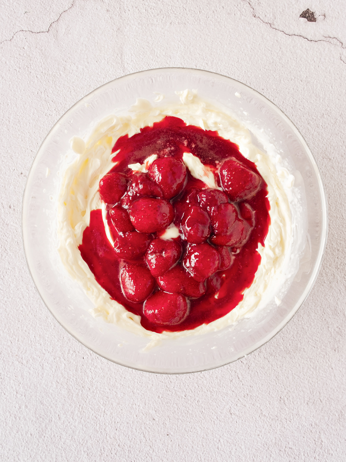 Sweetened strawberries on top of a mousse mixture.