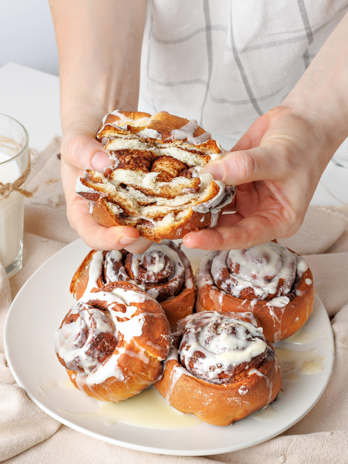 Hand showing the layers of cinnamon and dough.