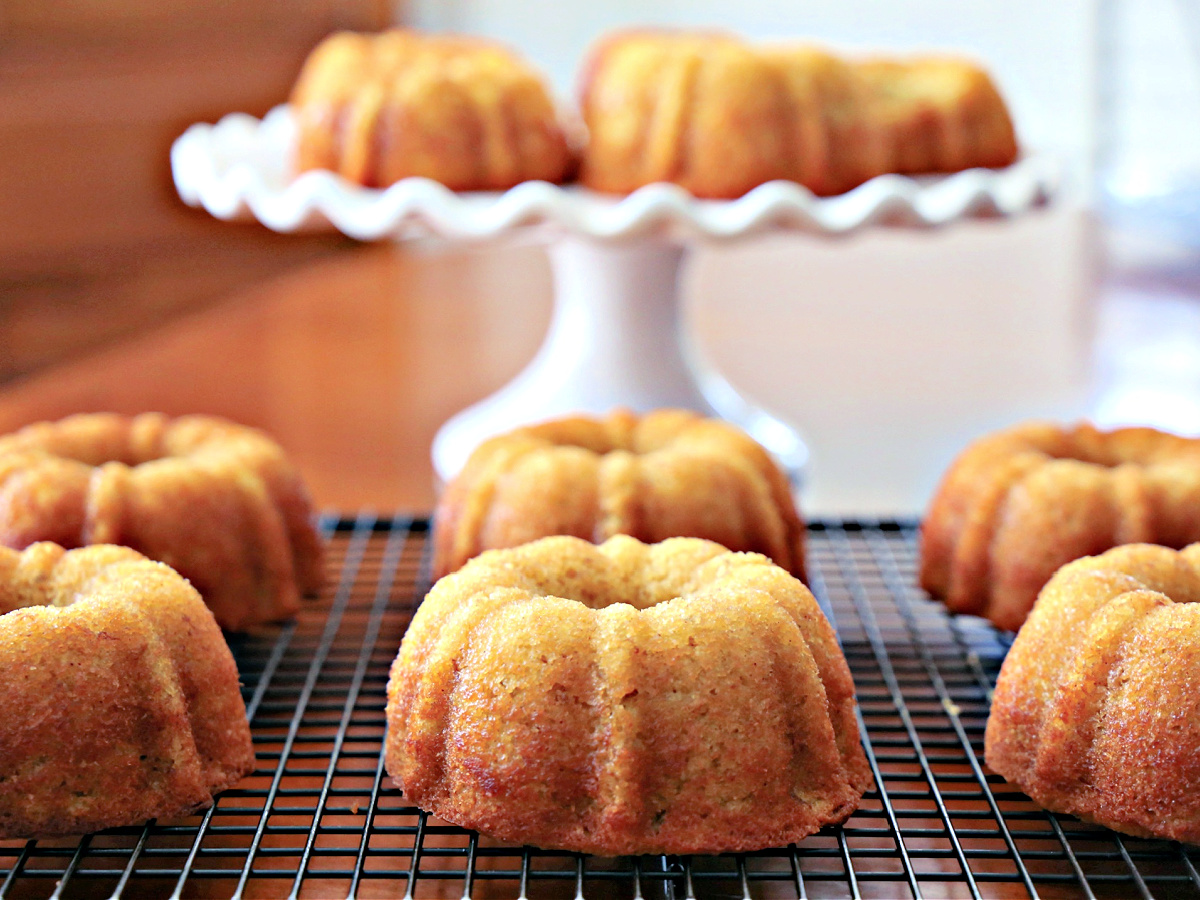 Mini bundt cakes on a wire rack and on a pedestal.