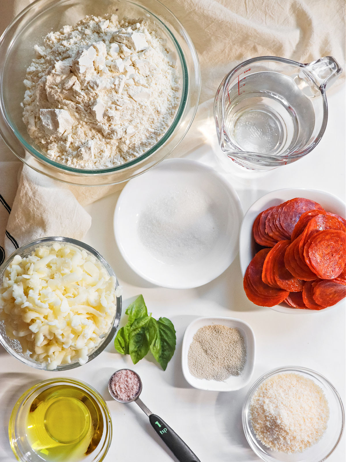 Flour, water, sugar, cheese, pepperoni, yeast and oil for making pizza bites.