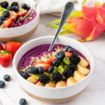 Freshly made smoothie bowl topped with fruit.